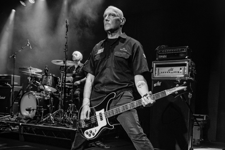 Black and white live performance photo of Australian rock band The Mark of Cain, featuring the bassist playing a Rickenbacker.